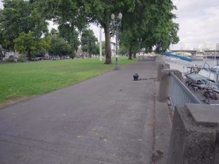 Blonde teen strolls naked along park promenade to show off